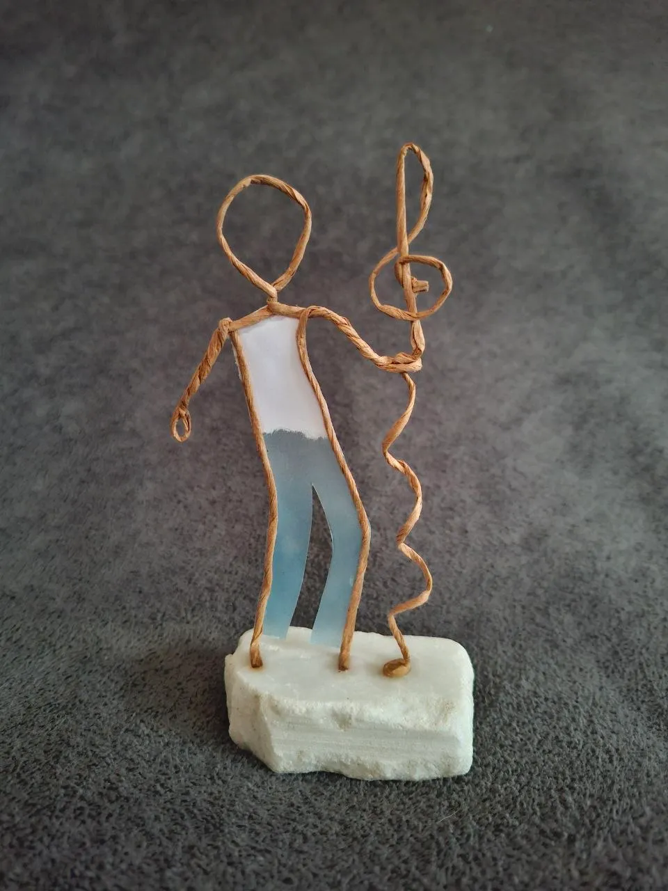 Papierdraht-Figur mit einem gedrahteten Notenschlüssel in der Hand