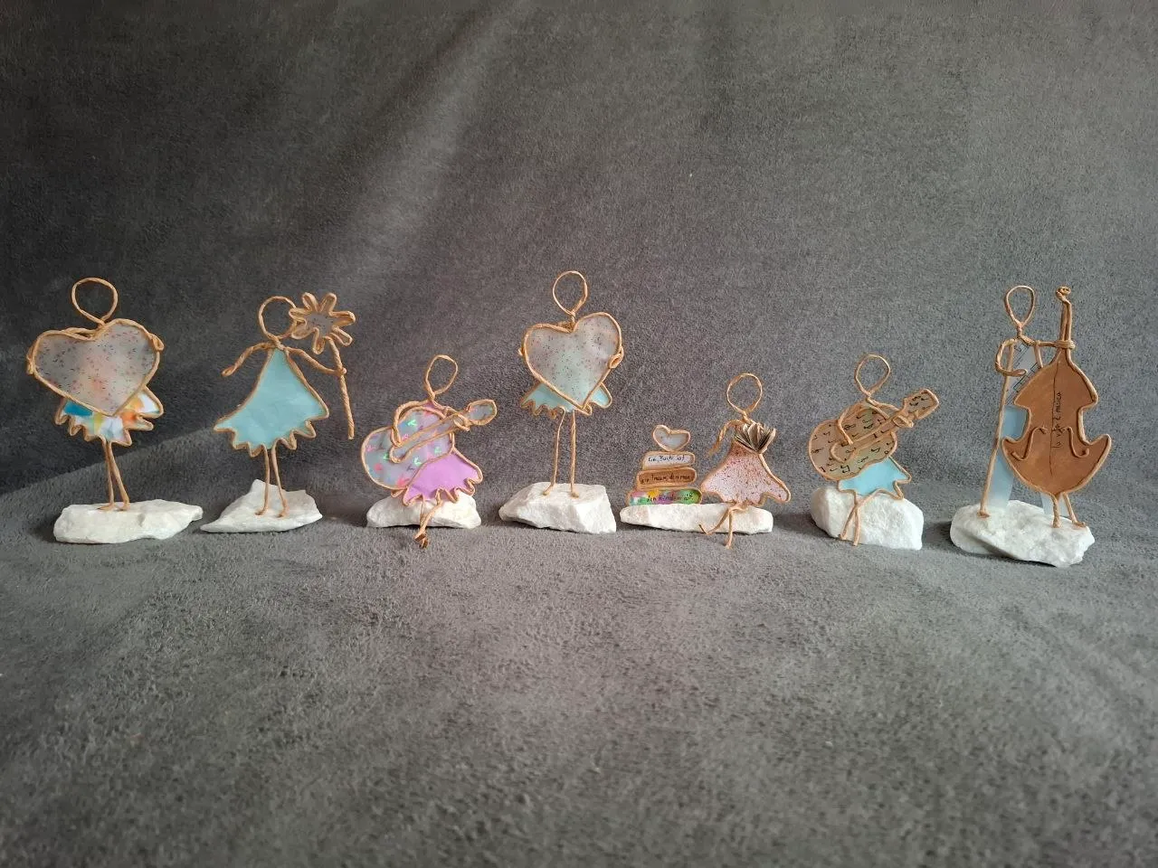 Gruppenfoto individuell gestalteter Papierdraht-Figuren auf kleinen Steinsockeln